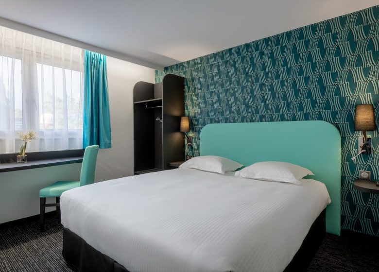 chambre - bleu lit chevet - zénith hôtel parc expo